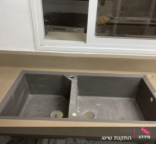 כיור כפול מותקן במשטח שיש במטבח